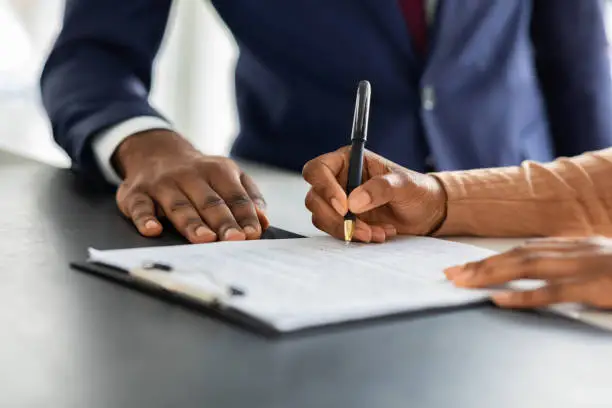 Two people signing a contract