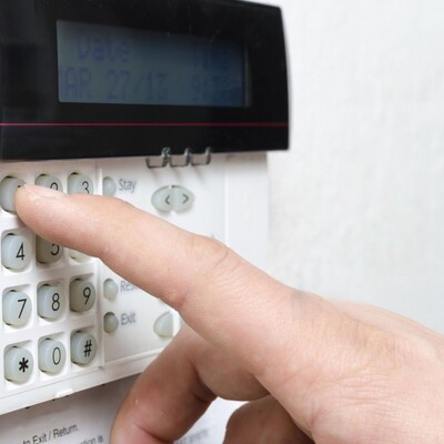 Man typing alarm code on keypad